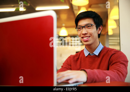 Cheerful young asian man using laptop Stock Photo