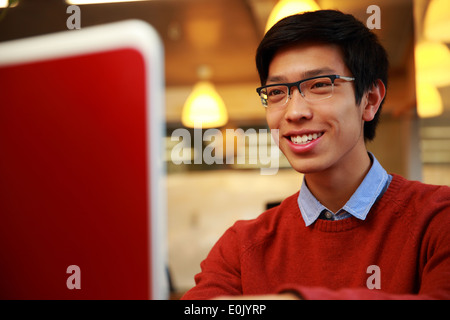 Happy young asian man looking at laptop screen Stock Photo