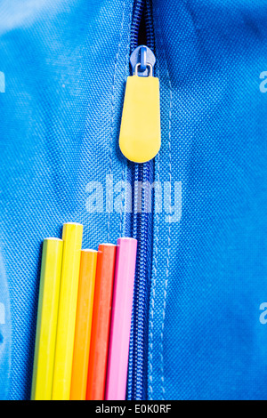 Colorful pens on blue school bag Stock Photo