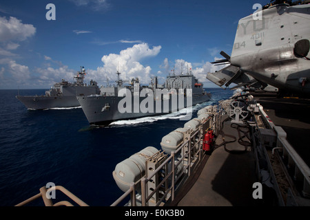 Sailors aboard USNS Washington Chambers, center, send fuel and supplies to Marines and sailors embarked aboard USS Pearl Harbor Stock Photo