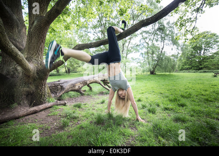 Blonde lady wearing black leggings and a grey crop exercising on hampstead heath. Stock Photo