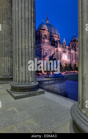 The Berlin Cathedral (Berliner Dom) through the columns of the Altes Museum at night. Stock Photo
