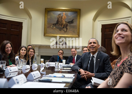 US President Barack Obama drops by an Affordable Care Act meeting in the Roosevelt Room of the White House March 12, 2014 in Washington, DC. Stock Photo