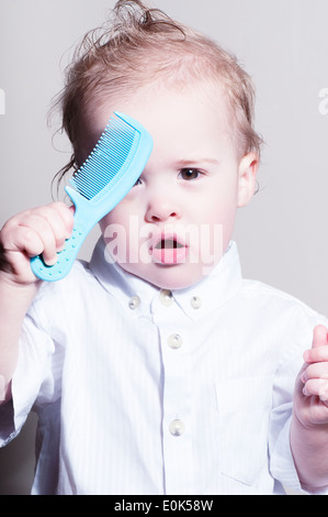 Cute Caucasian fifteen month old baby boy holding comb Stock Photo