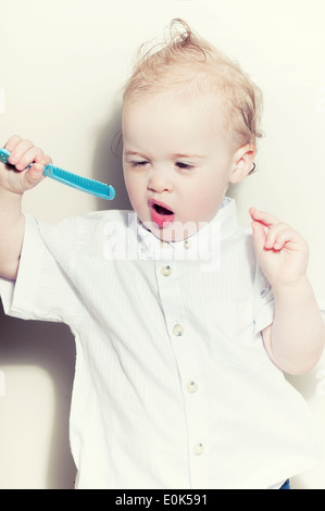 Cute Caucasian fifteen month old baby boy holding comb Stock Photo