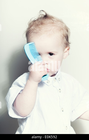 Cute Caucasian fifteen month old baby boy holding comb Stock Photo