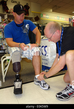 Nike representative Kevin Harper assists wounded warrior and member of Team Semper Fi, Marine Corps Cpl. Dustin Fleming, with s Stock Photo
