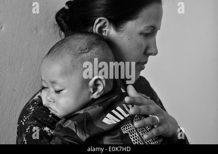 Senior Chief Petty Officer Anna Wood, hospital corpsman, holds a sleeping baby at a medical site in Kappa, Tonga, during Pacifi Stock Photo