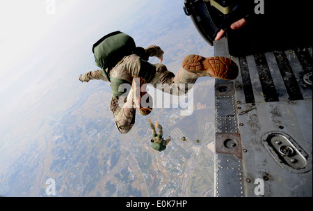 A pararescueman from the 31st Rescue Squadron freefalls with a parachute after jumping from a 33rd Rescue Squadron HH-60 Pave H Stock Photo