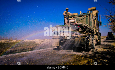 Marines with Engineer Company, Combat Logistics Battalion 3, 1st Marine Logistics Group (Forward) saturate the road with water Stock Photo