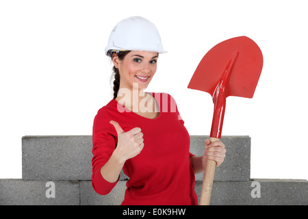 A female mason with a shovel. Stock Photo