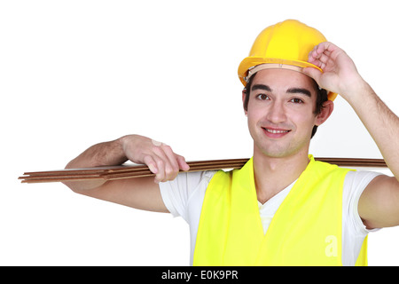 Construction worker carrying plywood Stock Photo