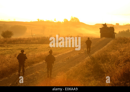 U.S. Army Europe soldiers of the 2nd Cavalry Regiment, patrol a road at the Grafenwoehr Training Area at sunrise during Saber J Stock Photo