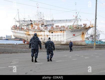 Navy Misawa sailors take a closer look at a fishing ship washed ashore in this tsunami-damaged city. Sailors from Naval Air Fac Stock Photo