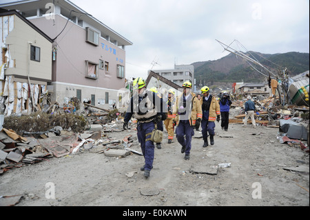 Members of the Fairfax County Urban Fire and Rescue Team head into downtown Ofunato to search for survivors following an 8.9-ma Stock Photo