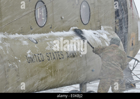 Soldiers with Task Force Wings, 159th Combat Aviation Brigade, 101st Airborne Division (Air Assault), clear snow from a CH-47 C Stock Photo