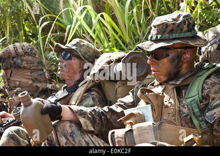 U.S. Marines attending Infantry Squad Leaders Course (ISLC), School of Infantry, West, rest during a hike on the Army's Kahuku Stock Photo