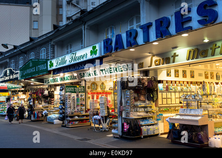 Religious icons and statues on sale at souvenir shops at pilgrimage location of Lourdes in Southern France Stock Photo