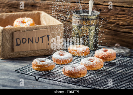 Icing sugar falling on fresh donuts Stock Photo