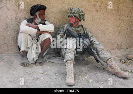 U.S. Army Command Sgt. Maj. Charles Cook, 4th Squadron, 4th Cavalry Regiment, 1st Infantry Division (right) talks with an older Stock Photo