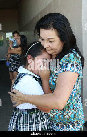 Los Alamitos, CA, USA. 14th May, 2014. Eight-year-old Olivia Cesneros cries with her grandmother Linda Wilson, after her father Julian returned from Afghanistan and surprised her at school. Sgt. Julian Cesneros, a soldier with the 349th Quartermaster Company in the 40th Infantry Division of the California National Guard, had completed two back to back deployments and had been away from his family for 11 months this time around. © Krista Kennell/ZUMAPRESS.com/Alamy Live News Stock Photo