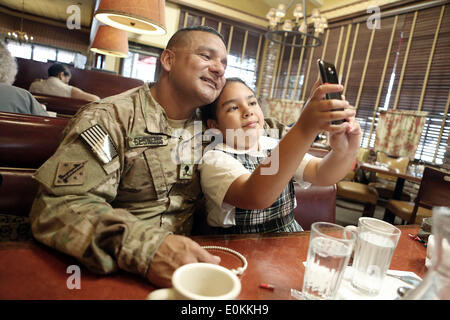 Los Alamitos, CA, USA. 14th May, 2014. Sgt. Julian Cesneros takes a selfie with his daughter Olivia in Los Alamitos, California. Julian, a soldier with the 349th Quartermaster Company in the 40th Infantry Division Julian, a soldier with the 349th Quartermaster Company in the 40th Infantry Division of the California National Guard, had completed two back to back deployments and had been away from his family for 11 months in Afghanistan this time around. © Krista Kennell/ZUMAPRESS.com/Alamy Live News Stock Photo