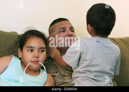 Los Alamitos, CA, USA. 14th May, 2014. Finally back home, Sgt. Julian Cesneros cuddles with his son Max and daughter Olivia in Garden Grove, California. Julian, a soldier with the 349th Quartermaster Company in the 40th Infantry Division of the California National Guard, had completed two back to back deployments and had been away from his family for 11 months in Afghanistan this time around. © Krista Kennell/ZUMAPRESS.com/Alamy Live News Stock Photo