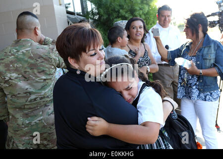 Los Alamitos, CA, USA. 14th May, 2014. Eight-year-old Olivia Cesneros cries with Laura Herzog of the military non-profit 'Honoring Our Fallen', after her father Julian returned from Afghanistan and surprised her at school. Sgt. Julian Cesneros, a soldier with the 349th Quartermaster Company in the 40th Infantry Division of the California National Guard, had completed two back to back deployments and had been away from his family for 11 months this time around. © Krista Kennell/ZUMAPRESS.com/Alamy Live News Stock Photo