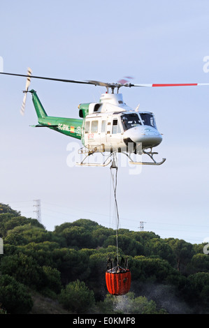 Bell 412 registration EC-IPM carrying water for fire fighting, Cabopino Golf, Costa del Sol, Spain. Stock Photo