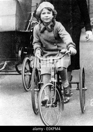 Young Queen Elizabeth II riding her bike Stock Photo