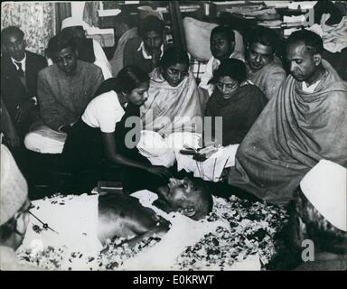 Feb. 02, 1948 - A Niece places flower Petals on the Brow of Mahatma Gandhi as he laid in State at Birla House - New Delhi. Photo shows a Niece of the Mahatma seen as she places flower petals on the Mahatma seen as she places flower petals on the Mahatma's brow as he laid in state at Birla House, New Delhi after his assassination. Immediately after this pictured was taken the procession left for the burning ghat on the banks of the River Jumna. four miles distant, where the cremation took place. Stock Photo