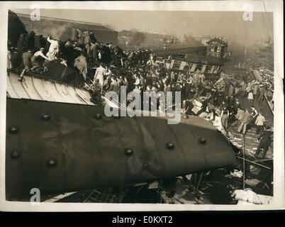 Oct. 10, 1952 - Many casualties in three train crash, big death roll feared: Three trains at the Night S another express and a local train crashed at Harrow and Wealdstone station this morning. One of the trains plodded into the platform, and wreckage was scattered all over the tracks. Photo shows the scene of the crush this morning showing reasoners at work. Stock Photo