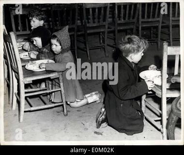 Feb. 02, 1953 - Flood victims receive assistance at the Canning Town Public Hall: Hundreds of flood victims from parts of Canning town spent last night at the Canning Town Public Hall. They expect to stay there until their homes have been freed from the waters. Photo shows four victims of the flood seen having a meal at the Canning Town Public Hall this afternoon.They are L -R: Graham Fordham; Charles Hunter; Christie Fordham and Stewart Fordham. Stock Photo