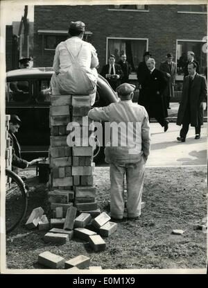 Mar. 03, 1953 - The Housing Minister visits the ''12 day House'' at Hemel Hempstead: Mr. Harold McMillen the Housing Minister yesterday paid a visit to the Housing Estate at Hemel Hempstead where he inspected a house which had been constructed in 12 days. Photo shows One man squats on a pile of bricks which another takes it easy alongside as mr. McMillen arrives at the ''12 Day House'' during his inspection yesterday. Stock Photo