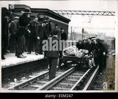 Apr. 04, 1953 - Nine now dead in Tube disaster; Nine people were known today to have died in the Central Line tube disaster at Street ford the worst in the London's Underground history. It was the second coach of the Ealing broadway apping train which took the brunt of the crach. The train ran into the rear of another train travelling from Greenford to Helneult. Photo Shows Rescue workers seen emerging from the tunnel as they bring bodied on a trolley into Stratford Station this morning. Stock Photo