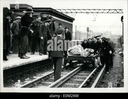 Apr. 04, 1953 - Nine Dead in Tube Disaster: Nine people were known today to have died in the Central Line tube disaster at Stratford last night the worst in London's Underground history. It was the second coach of the Ealing Broadway-Epping train wich took the brunt of the crash. The train ran into the rear of another train travelling from Greenford to Hainault. Photo shows Rescue workers seen emerging from the tunnel as they bring bodies on a trolley into Stratford Station this morning. Stock Photo