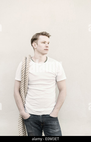 Portrait of young man with a rope. Pensive expression and looking away. Stock Photo