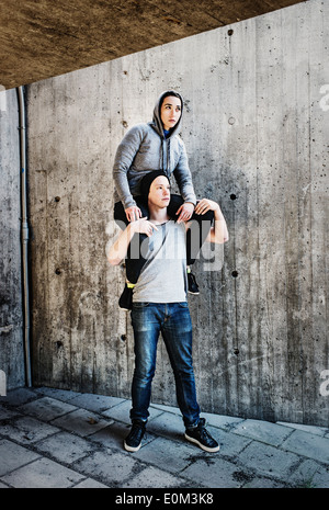 Portrait of young man carrying woman on his shoulders in urban setting. Stock Photo