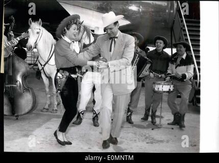 Apr. 04, 1956 - SINGING COW BOY ARRIVES IN PARIS EDDIE SMITH, THE FAMOUS AMERICAN SINGING COW BOY WHO WILL PARTICIPATE IN THE GREAT RODEO TO BE HELD IN PARIS IN APRIL 20 ARRIVED AT ORLY AIRPORT THIS MORNING. EDDIE GIVING A DANCE TO JACQUELINE JOUBERT, FRENCH STARLET, WHO DONNED A WILD-WEST DRESS TO GREET THE COW BOY. Stock Photo