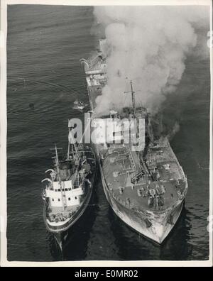May 05, 1956 - Channel Ship Ablaze After Collision: The 9,074-Norwegian tanker, Erling Borthen, burst into flames after colliding with the 7,179-ton Panamanian steamer, Santa Rosa. The collison occurred in dense fog off Beachy Head seen after dawn. One death is reported and six men severely burned, several of whom are members of the crew of the Santa Rosa. Rescue ships were severely hindered by the intense heat and cascading petrol set the sea on fire. Photo shows An aerial view showing a tug tied up alongside to play hoses on the burning tanker. Stock Photo