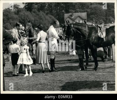 May 05, 1956 - Queen and her children watch Duke playing Polo at Windsor.: Prince Charles and Princess Anne with their Mother the Queen - watched the Duke of Edinburgh playing polo at Windsor Great Park yesterday. Photo shows the Duke feeds his pony - while the Queen and her children can be seen on left when they visited Windsor Great Park yesterday. Stock Photo