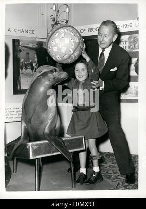 Oct. 10, 1956 - The Lyon Family Hold Party For Spastics Seals Field Seal Sale; Ben Lyon - Bebe Daniels and their children Barbara and Richard held a Coffee Party at the Waldorf Hotel this morning in aid of the National Spastics Society. Spastic children were entertained by Colette and Columbine, performing Seals - when the NSS Christmas Seal Campaign was inaugurated. Photo shows Eight year old Jean Cantley of Ruislip - tries balance a ball on one of the Seals with the assistance of Ben Lyon - at the Party today. Stock Photo