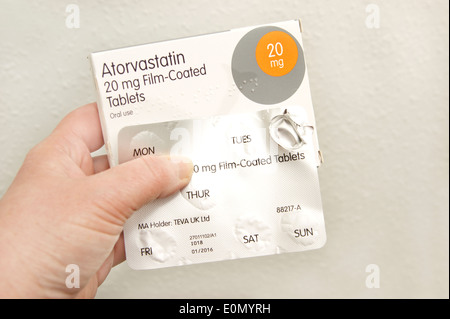 Woman holding a pack of Atorvastatin tablets (statins) Stock Photo