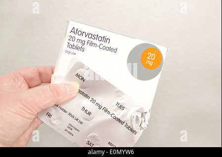 Woman holding a pack of Atorvastatin tablets (statins) Stock Photo