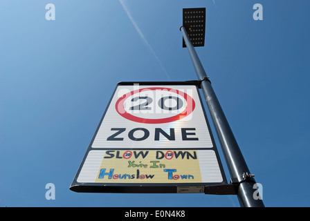 british road sign indicating 20mph zone with local wording beneath stating slow down you're in hounslow town Stock Photo