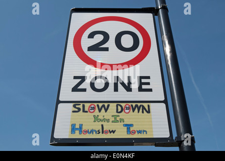 british road sign indicating 20mph zone with local wording beneath stating slow down you're in hounslow town Stock Photo