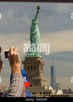 Tourists photographing the Statue of Liberty from the Statue Cruises boat Stock Photo