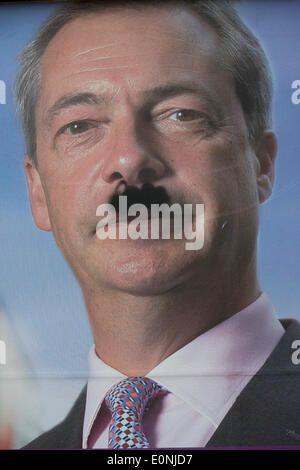 London, UK. 17th May 2014: An anti-EU membership 'UK Independence Party's (UKIP) political billboard showing party leader Nigel Farage with a daubed Hitler moustache in East Dulwich - a relatively affluent district of south London. The ad is displayed before European elections on 22nd May. Copyright Richard Baker / Alamy Live News. Stock Photo