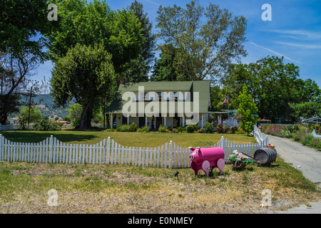 A farm house with a pink metal pig in front in Santa Margarita, California. An example of American folk art. Stock Photo