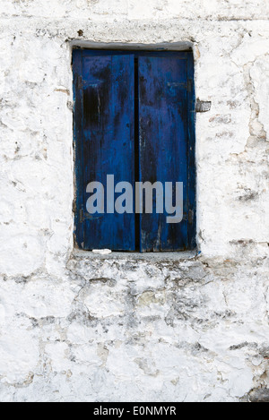 Blue shutter in a peeling brick wall Stock Photo